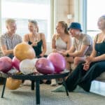 Joukko nuoria aikuisia viettävät syntymäpäiviä ja hymyilevät.